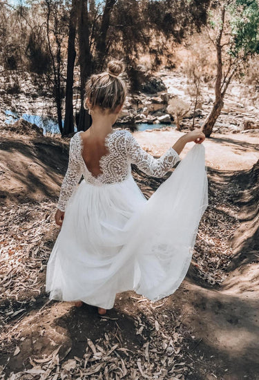 Back full length shot of model holding the White Swan Lace Back Dress skirt